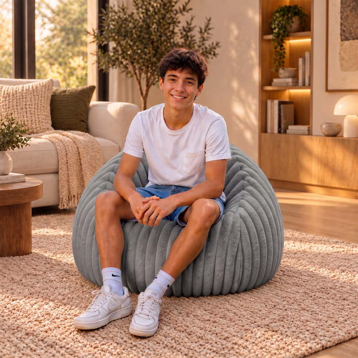 Personne assise confortablement dans un pouf poire en fourrure côtelée