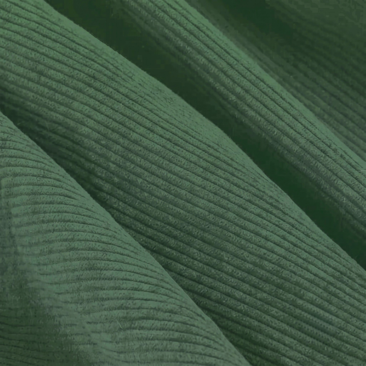 Détail du velours côtelé vert du pouf déhoussable, texture nervurée.