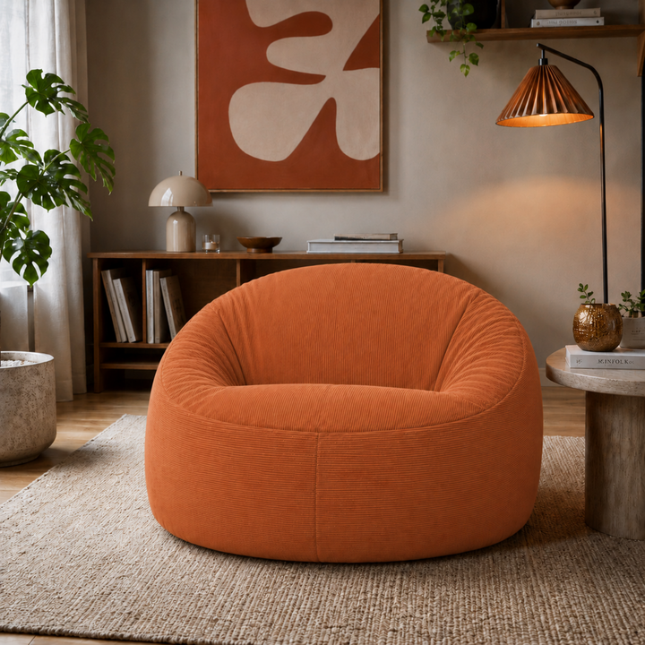 Pouf déhoussable en velours côtelé terracotta, forme ronde capitonnée.