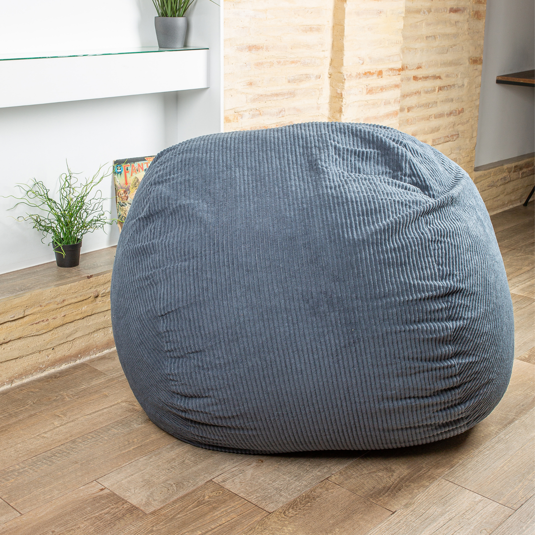 Pouf-lit convertible 2-en-1 bleu foncé, forme arrondie avec texture côtelée, dans un salon