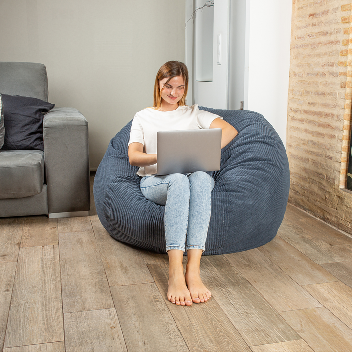 Personne assise sur le pouf-lit convertible 2en1, forme ronde confortable
