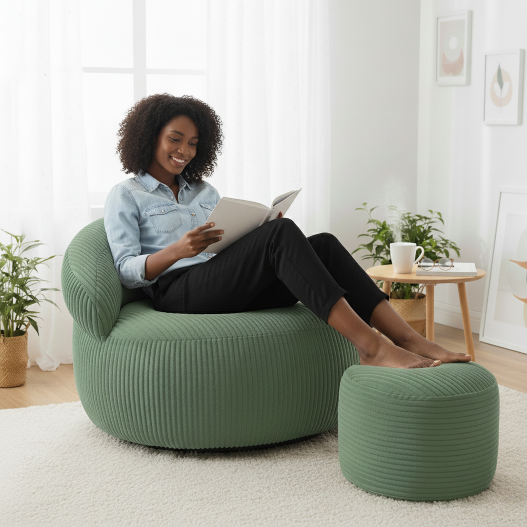 Personne assise confortablement sur un pouf XXL en velours côtelé avec repose-pieds, dans un salon