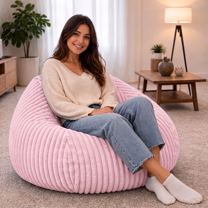 Personne assise confortablement dans un pouf poire en fourrure côtelée