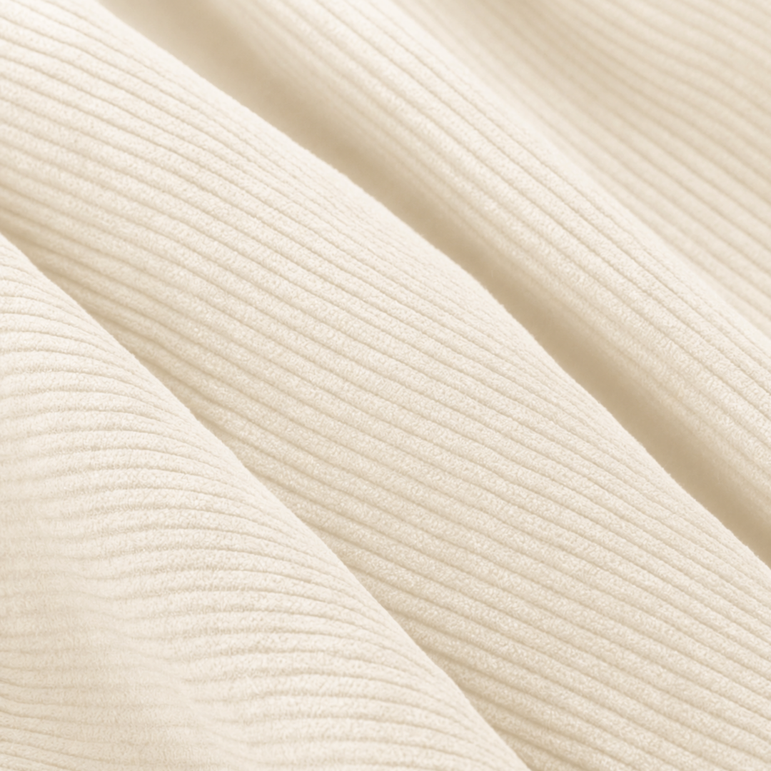 Gros plan du velours côtelé écru avec texture nervurée régulière.