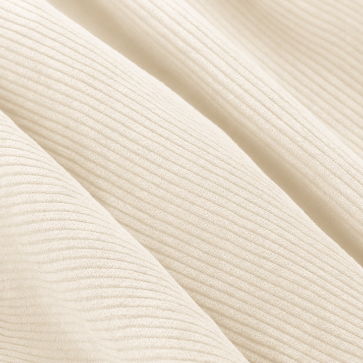 Gros plan du velours côtelé écru avec texture nervurée régulière.