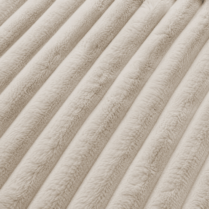 Tissu en fourrure côtelée beige, texture à relief visible.
