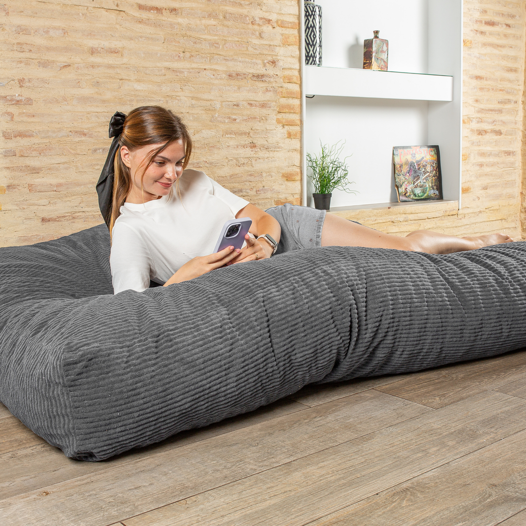 Personne allongée sur le pouf-lit convertible 2en1, utilisé en couchage pour se détendre