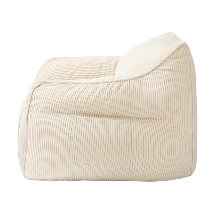 Pouf fauteuil en velours côtelé blanc cassé, vue de côté, coutures verticales et renforts.