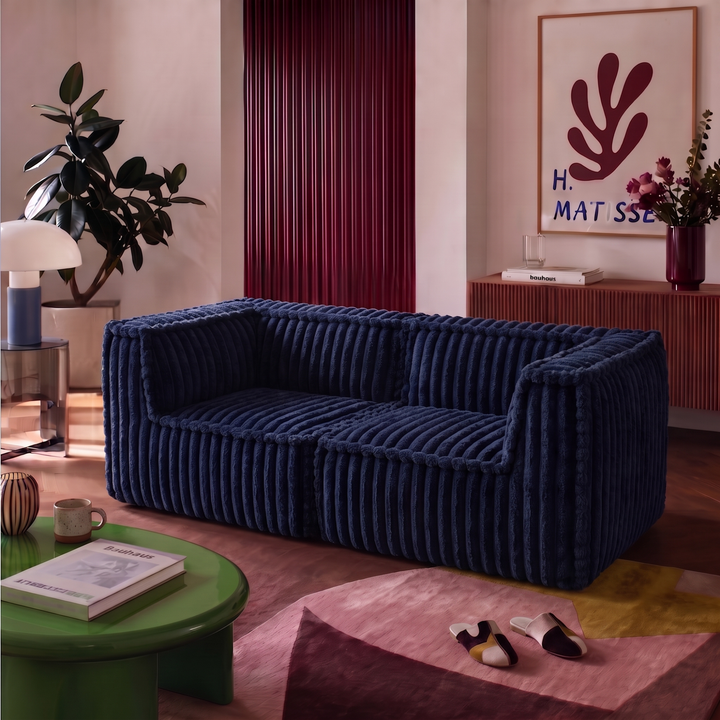 Canapé modulable 2 places bleu en fourrure côtelée, assise avec accoudoirs dans un salon