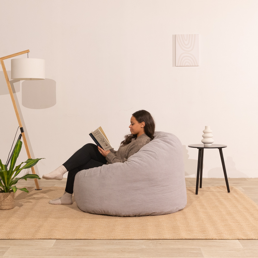 Personne assise confortable sur un pouf en velours côtelé épais