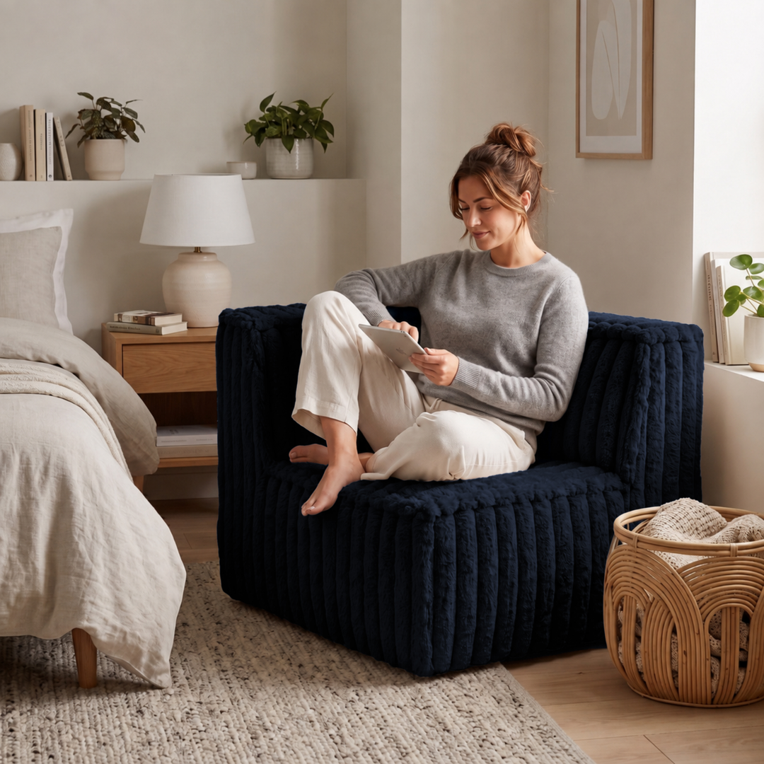 Femme assise dans un module d’angle gauche déhoussable en fourrure côtelée bleu foncé.